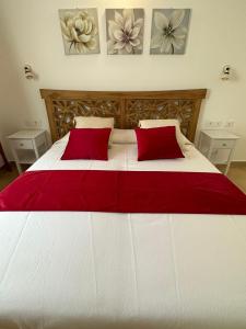 - un grand lit blanc avec des oreillers rouges dans une chambre dans l'établissement Maria Caderina Green Village, à Posada