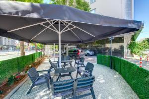 a table and chairs under an umbrella on a sidewalk at Bera Konya Hotel in Konya