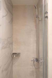 een badkamer met een douche en een glazen deur bij Newly Renovated 2 Bedroom Apartment, 5min to metro in Athene