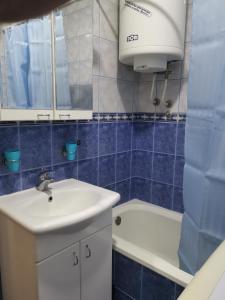 a blue tiled bathroom with a sink and a toilet at Dunav 009 in Veliko Gradište