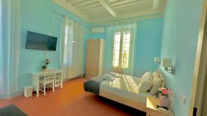 Cette chambre bleue comprend un lit et une télévision. dans l'établissement B&B - Residenza d'epoca Piazza Cairoli, à Pise