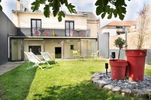 a house with a yard with chairs and a balcony at Maison et Jardin - Chambre Cosy in Amiens