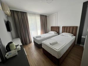 um quarto de hotel com duas camas e uma televisão em Donna em Ulcinj