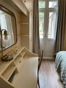 1 dormitorio con espejo, lavabo y cama en West London stunning garden flat - period features, en Londres