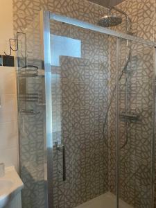 W łazience znajduje się prysznic ze szklanymi drzwiami. w obiekcie West London stunning garden flat - period features w Londynie