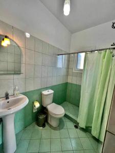 a bathroom with a toilet and a sink at J&B Rooms Dhermi in Dhërmi