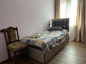 1 dormitorio con cama, silla y ventana en Arman Bed and Breakfast en Halidzor