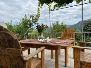 einem Holztisch mit zwei Stühlen und einer Vase aus Blumen in der Unterkunft Arman Bed and Breakfast in Halidzor