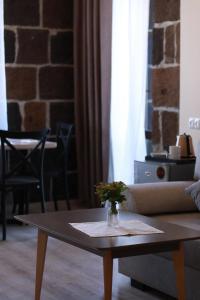 a coffee table with a vase of flowers on it at ZERO GUESTHOUSE in Gyumri