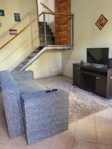 Departamento Mendoza في مايبو: غرفة معيشة مع أريكة وتلفزيون ودرج