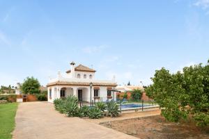 ein großes weißes Haus mit einem Pool davor in der Unterkunft Villa Juani Sólo familias in Roche