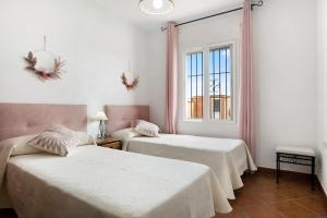 zwei Betten in einem Zimmer mit Fenster in der Unterkunft Villa Juani Sólo familias in Roche + 18 Fotos