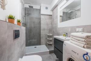 W łazience znajduje się prysznic, umywalka i pralka. w obiekcie Imperial Apartments - Baltica w mieście Sopot