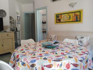 una camera da letto con un letto con una trapunta colorata di Appartamento La Terrazza - Località Cala Gavetta a La Maddalena