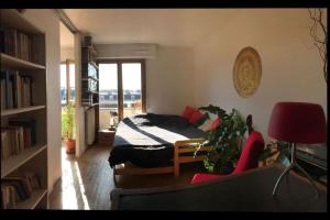 a bedroom with a bed and a chair and a window at Le charme de Montmartre à ciel ouvert in Paris