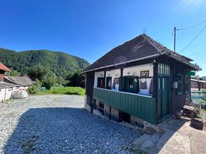 a small green and white building on a gravel road at Casa Verde in Lupşa