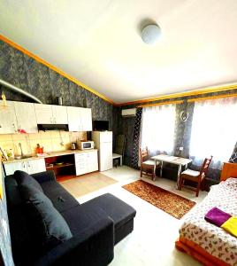 a living room with a black couch and a kitchen at Be real центр квартира кондиціонер in Ivano-Frankivsʼk