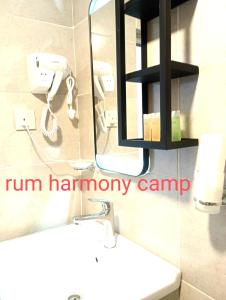 a bathroom with a sink and a phone on the wall at Rum Armony camp in Wadi Rum