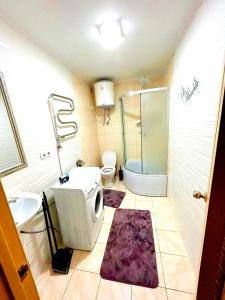 ein Bad mit einer Dusche, einem WC und einem Waschbecken in der Unterkunft Be real центр квартира кондиціонер in Iwano-Frankiwsk