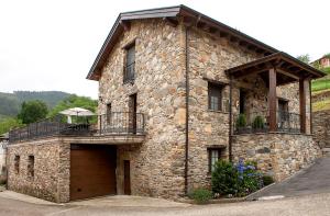 Bustiello de Paredes的住宿－Apartamentos Rurales Posada de las Hoces，一座大型石头建筑,设有两个阳台