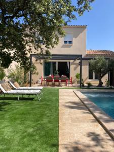 une cour arrière avec une piscine et une maison dans l'établissement Villa les Romarins, à Saint-Didier