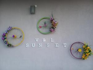 drie paraplu's op een muur met de woorden muur zonsondergang bij V&L Sunset in Ioannina