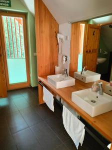 bagno con 2 lavandini e specchio di Hotel Jelka Pokljuka a Podjelje