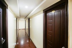 a hallway with a brown door at OYO Flagship Hotel J.B. Paradise in Vānivilāsa Puram