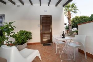 een patio met een tafel, stoelen en planten bij B&B Kòre in Castellammare del Golfo