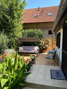 a garden with a bed and a chair on a patio at CSAOL Apartman ház in Velence