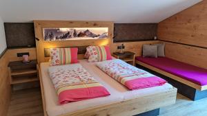 1 Schlafzimmer mit 2 Betten und rosa Bettwäsche in der Unterkunft Appartements Alpenland - Ferienwohnungen in Auffach