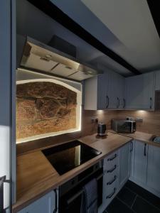 a kitchen with a sink and a stove top oven at Puffin Cottage in Boddam