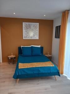 een slaapkamer met een blauw bed met blauwe kussens bij Les gîtes Ambleteuse in Ambleteuse
