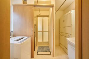 a small kitchen with a sink and a washer and dryer at Guest House Kingyo - Vacation STAY 14497 in Sapporo