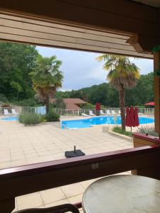 a view of a swimming pool through a window at Chalet 17 tournesol Mauroux in Mauroux