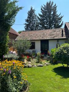 a house with a garden with flowers in the yard at CSAOL Apartman ház in Velence