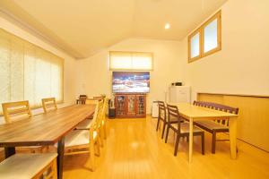 a dining room with a large wooden table and chairs at Guest House Kingyo - Vacation STAY 14498 in Sapporo