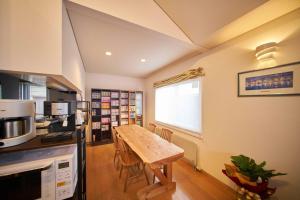 Guest House Kingyo - Vacation STAY 14498 في سابورو: مطبخ مع طاولة خشبية في الغرفة