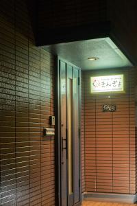 Una puerta en un edificio con un cartel. en Guest House Kingyo - Vacation STAY 14498 en Sapporo