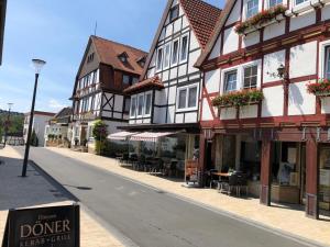une rue avec des bâtiments, des tables et des chaises dans l'établissement Haus Blick am Edersee, à Waldeck