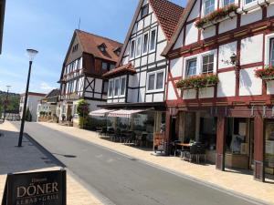 eine Straße mit einigen Gebäuden, Tischen und Stühlen in der Unterkunft Haus Blick am Edersee in Waldeck