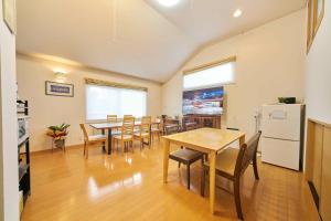 uma sala de jantar com mesas e cadeiras e um frigorífico em Guest House Kingyo - Vacation STAY 14499 em Sapporo