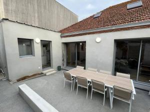 a wooden table and chairs in front of a building at La Girase in Saint-Gilles-Croix-de-Vie