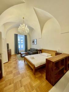 una camera con letto, divano e lampadario a braccio di Masná 20C- Old Town Residence a Praga