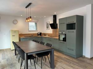 a kitchen with a table and chairs in a kitchen at La Girase in Saint-Gilles-Croix-de-Vie