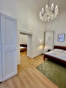 una camera da letto con un letto e un lampadario di Masná 20C- Old Town Residence a Praga