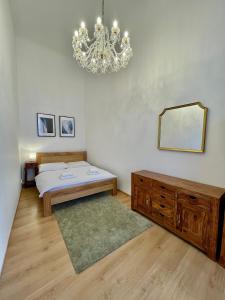 una camera da letto con un letto e un lampadario di Masná 20C- Old Town Residence a Praga Altre 4 foto
