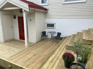una terraza de madera con mesa y sillas en una casa en WALO APARTMENTS Tromsø - Alfheim 10 min walk to city centre - No parking, en Tromsø