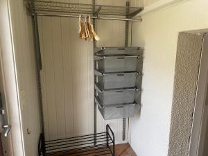 Una habitación con un armario con varias cestas y un estante. en WALO APARTMENTS Tromsø - Alfheim 10 min walk to city centre - No parking, en Tromsø