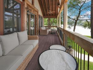 une véranda avec un canapé et une table dans l'établissement Lakefront Lodge with King Beds and Game Lounge, à Worthville